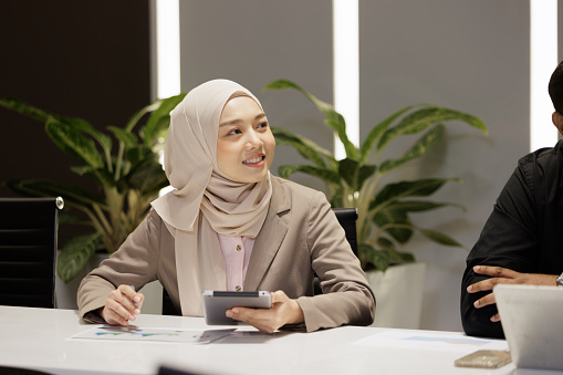 Confident Muslim woman in meeting room
