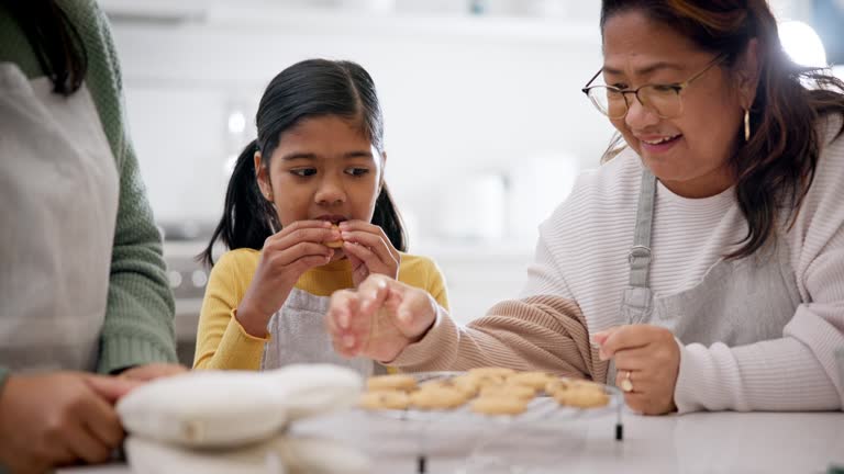 Mother, grandmother and child excited for cookies in kitchen, teaching and learning together with family in home. Mom, grandma and young baker girl with sweets, generations sharing recipe with love.