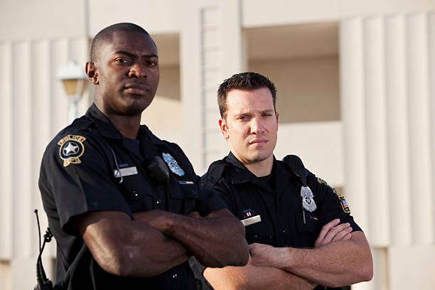 Police officers Multi-ethnic police officers (20s).  Focus on Caucasian man. macho photos stock pictures, royalty-free photos & images