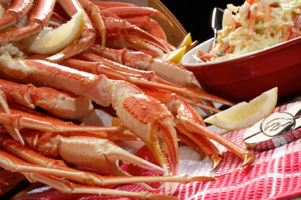 Alaskan Snow crab Alaskan snow Crab picnic with coleslaw. eating crab legs stock pictures, royalty-free photos & images