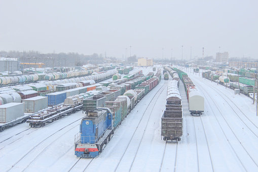freight trains at a railway station covered with snow during a snowfall