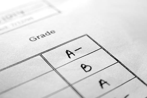 An up close picture of report card grades Macro shot of A- on white results sheet. Extremely shallow focus. ranking school stock pictures, royalty-free photos & images