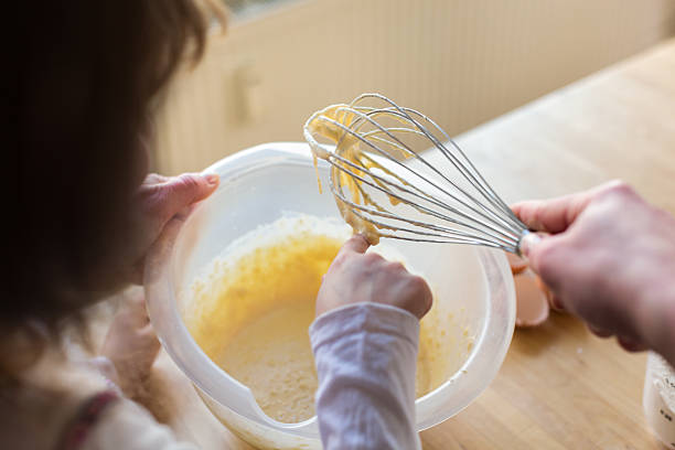 niña probar la masa de tarta - family germany baking berlin germany fotografías e imágenes de stock