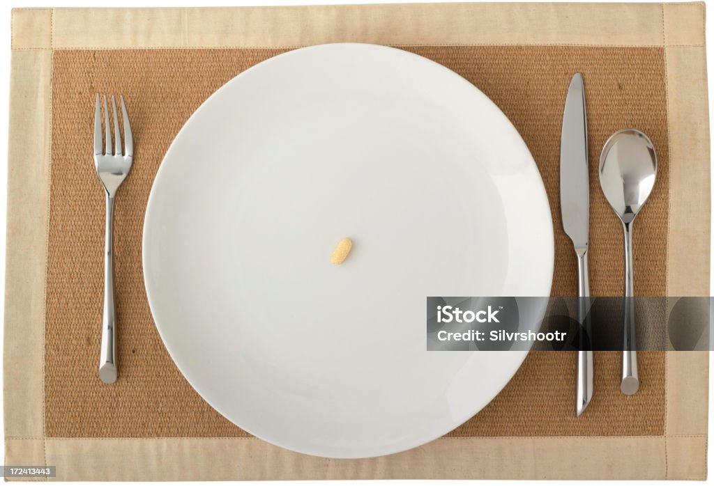 Diet Plate A solitary pill on a white place setting Eating Disorder Stock Photo