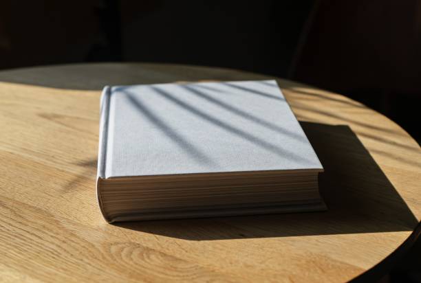 istock Book with white cover lying on wooden table 1724134960