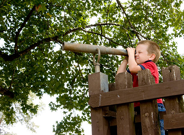 Little boy looking through a tube by a wooden gate Please see images with a similar theme in my portfolio: spy games stock pictures, royalty-free photos & images