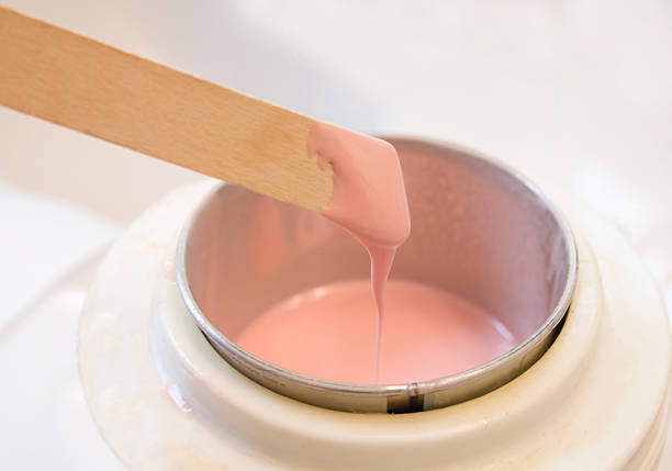 Hot pink wax used for hair removal Wax on a stick ready to spread. wax photos stock pictures, royalty-free photos & images