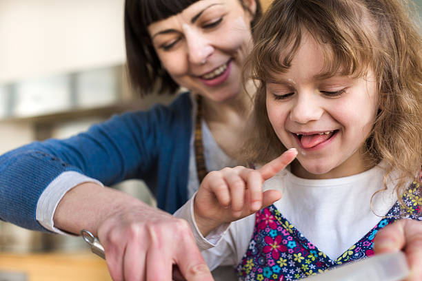 niña probar la masa de tarta - family germany baking berlin germany fotografías e imágenes de stock