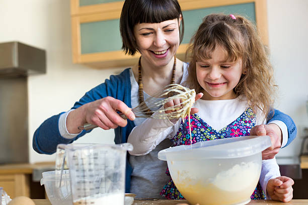 mãe e filha bicarbonato um bolo juntos - family germany baking berlin germany imagens e fotografias de stock