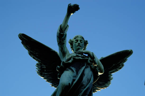 Statue of Angel Looks Down From Blue Sky