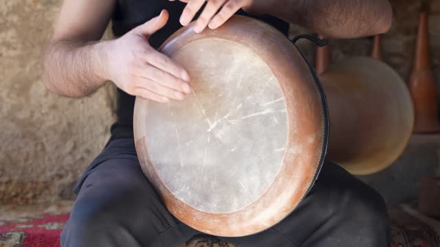 a man playing the goblet drum