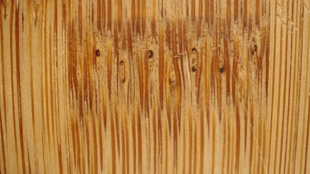 Texture and fibers of a bamboo cutting board, with knife marks. Macro slider.