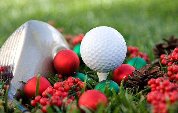 Holiday style closeup of golf tee with gold ball and club stock photo