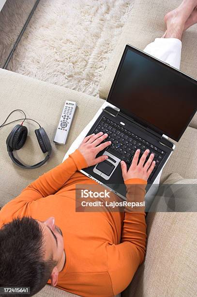 A Man Working At Home In A Laptop With Headphones And Remote Stock Photo - Download Image Now