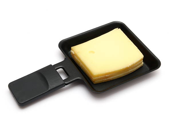 Raclette cheese in a square pan in a white background