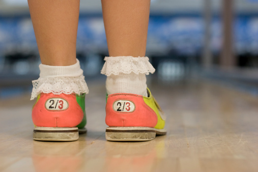 Child stands on bowling alley. Numbers on back are US shoe sizes (fits sizes two to three).