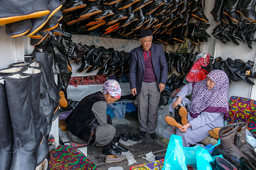 Osh, Kyrgyzstan - October 8, 2023: A man selling shoes at the Jayma Bazaar in Osh, Kyrgyzstan.