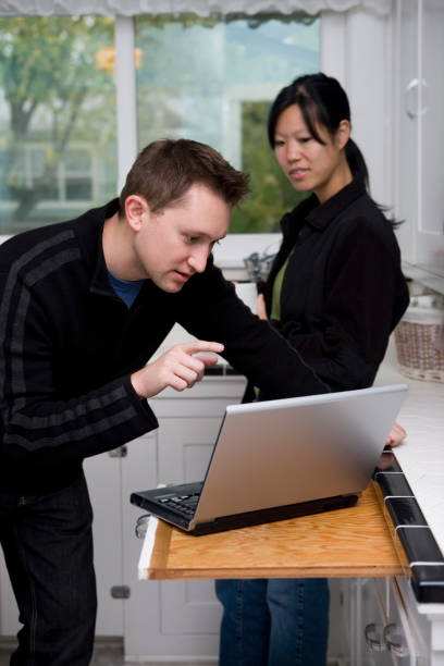 istock Asian Wife with Caucasian Husband Using Laptop in Home Kitchen 172416683