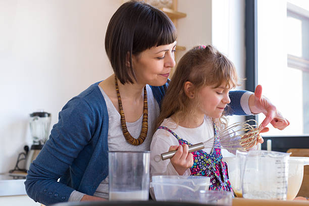 menina degustação massa de bolo - family germany baking berlin germany - fotografias e filmes do acervo