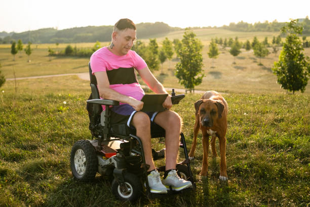istock A young gay with a disability is seen enjoying time with his dog while using a tablet. 1724172590