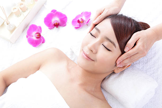 美しい若い女性の受信顔のマッサージをお楽しみください。 - beauty spa spa treatment health spa orchid ストックフォトと画像