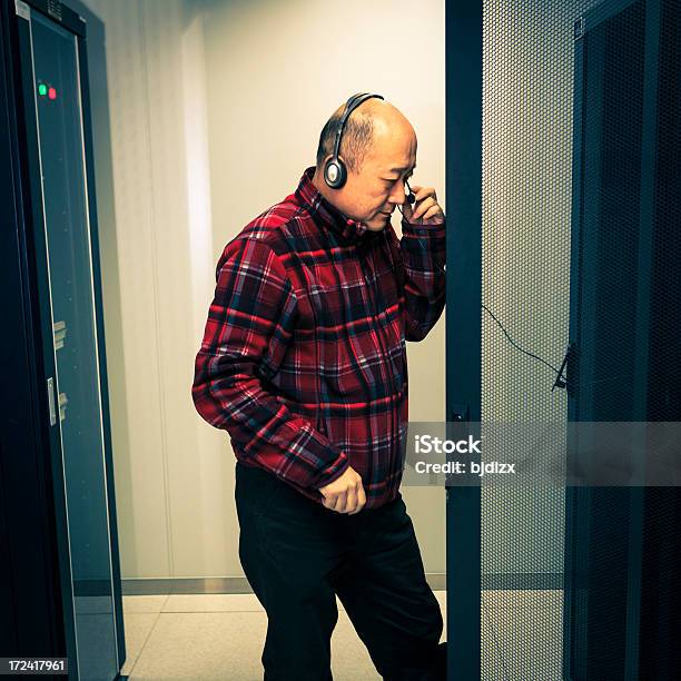 Technician Working On A Server With Headsets Stock Photo - Download Image Now - 50-54 Years, Administrator, Adult