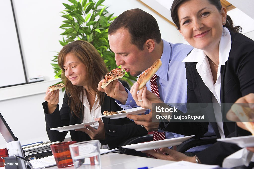 Eating on the meeting Young business people having funny launch break Adult Stock Photo