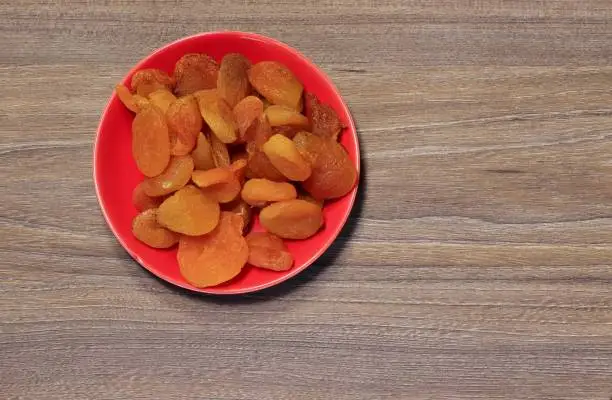 Photo of Dried apricot fruits on a saucer.