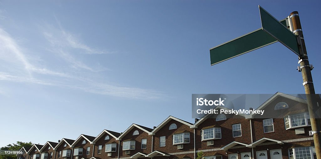 Fila di case a schiera immobiliare vuoto Street le indicazioni Blu Sky - Foto stock royalty-free di Formina per dolci