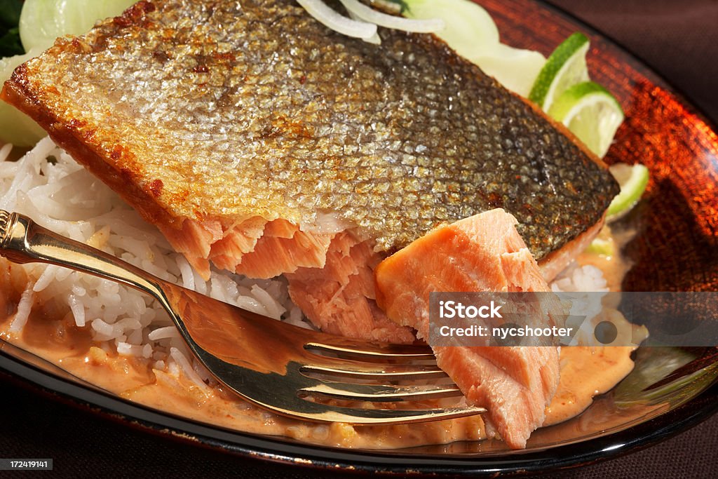 Pan fried salmon Pan fried salmon with skin over a bed of white rice. Acid Stock Photo