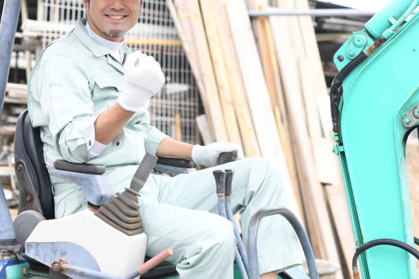istock A middle-aged Asian male worker does a fist pump while operating construction machinery at a construction site. 1724203726
