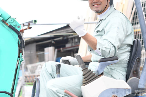istock A middle-aged Asian male worker does a fist pump while operating construction machinery at a construction site. 1724212447