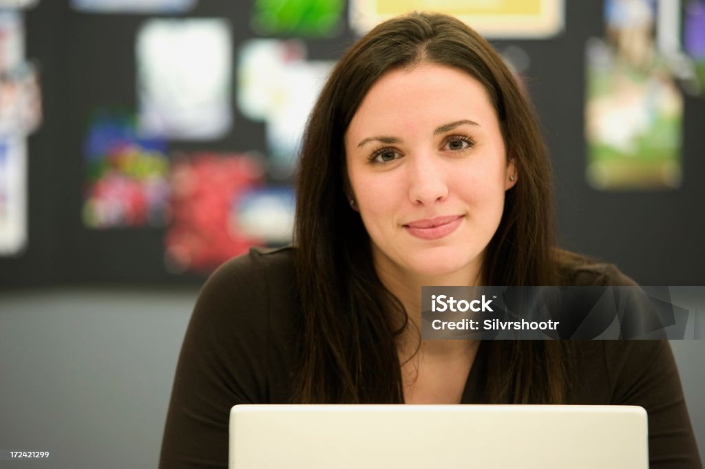 Mulher sorridente em ambiente de escritório - Foto de stock de A caminho royalty-free