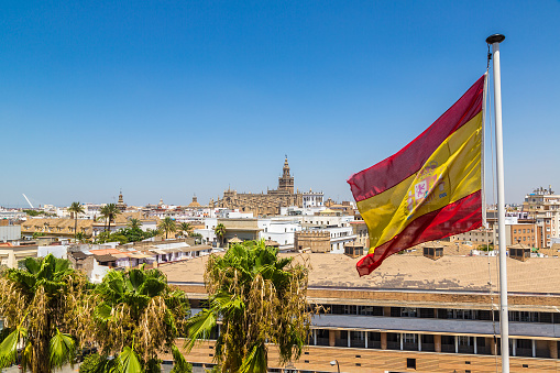 Spain flag and panoramic aerial view of Sevilla in a beautiful summer day, Spain