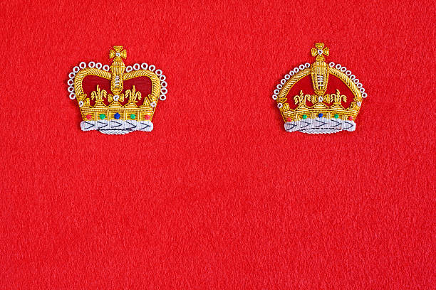 Kings and Queens "The embroidered Queenaas Crown badge on the left and the Kingaas Crown badge on the right on a red baize background. These iconic depictions relate to the crowns as worn at the Coronation of British monarchs, Queens Victoria and Elizabeth II and Kings, Edward VII, George V and George VI. Good copy space." george vi stock pictures, royalty-free photos & images