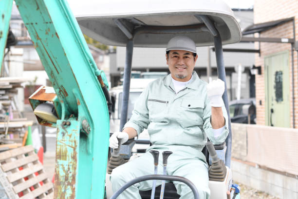 istock A middle-aged Asian male worker does a fist pump while operating construction machinery at a construction site. 1724221408