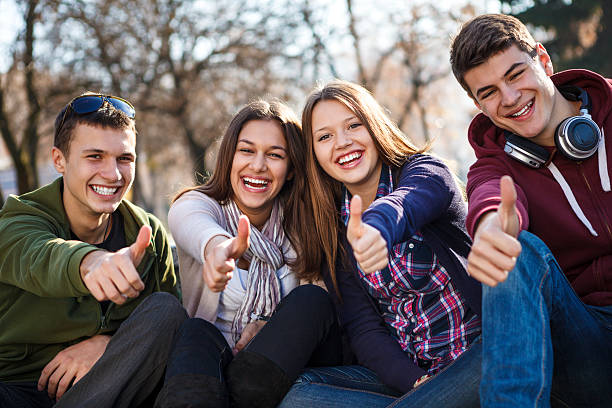 group of happy подростковой друзей, показывая пальцем вверх - thumbs up teenager adolescence group of people стоковые фото и изображения