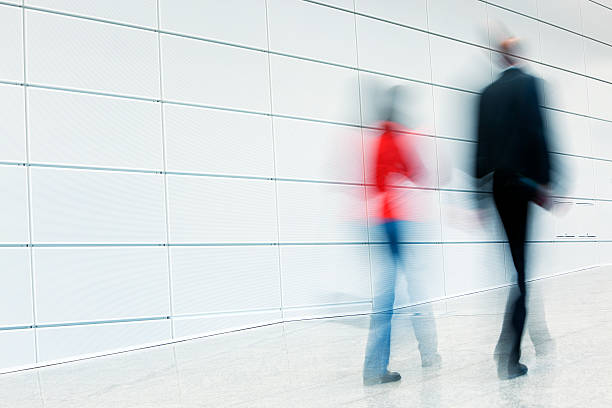 istock Man and Woman Walking Down White Hallway, Blurred Motion 172422448
