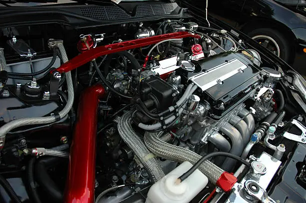 A modified motor running under the hood of a sport compact car.