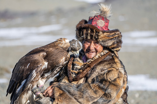 Bayan-Olgii Province, Mongolia - September 28, 2023: An ethnic Kazakh eagle hunter and his golden eagle.