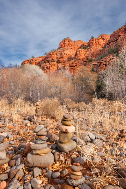 Rock Cairns at Buddha Beach Buddha Beach is a place along Oak Creek in the Verde Valley where people stack river rocks into cairns. Perhaps they are trying to capture the energy of the mysterious vortex that supposedly exists there. Or perhaps they want to imitate the shape of the Buddha in each sculpture. At any rate, hundreds of these mini Buddhas are constructed each year only to wash away each summer in the monsoon floods. Buddha Beach is at Red Rock Crossing in the Coconino National Forest near Sedona, Arizona, USA. jeff goulden sedona stock pictures, royalty-free photos & images