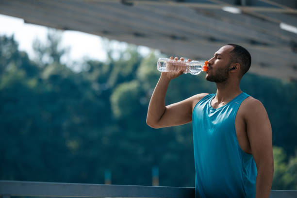 istock Well-built handsome sportsman drinking water after workout 1724239177