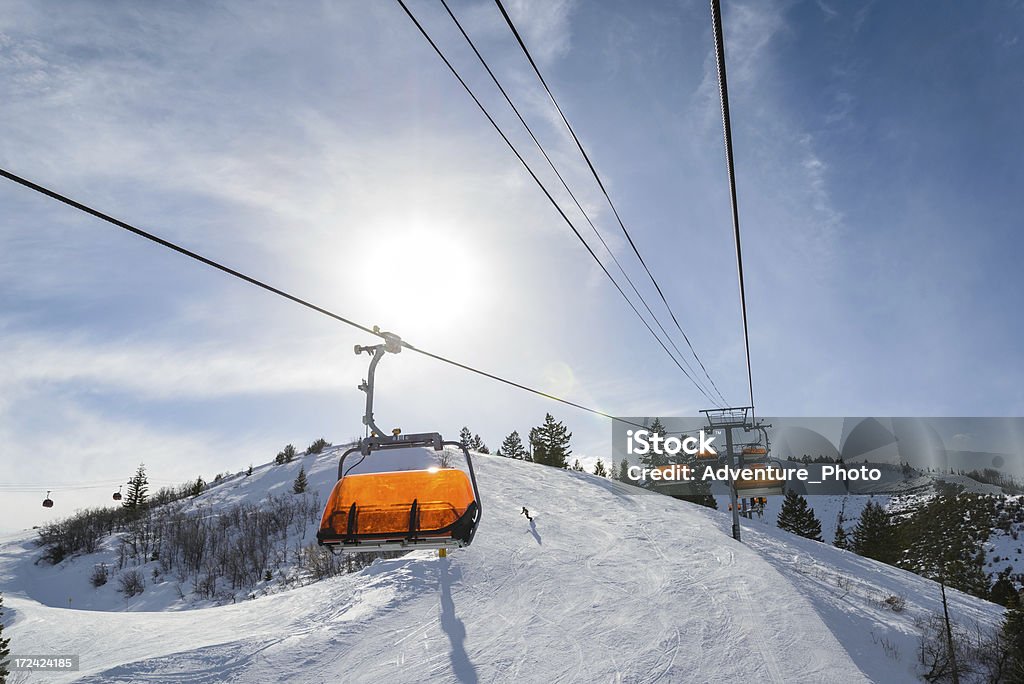 Riding Chairlift in Winter "Park City, Utah orange covered ski lifts with sun on sunny day.  Riding up chairlift late in the afternoon.  Captured as a 14-bit Raw file. Edited in 16-bit ProPhoto RGB color space." Park City - Utah Stock Photo