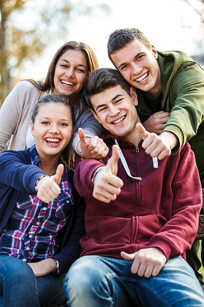 group of happy подростковой друзей, показывая пальцем вверх - thumbs up teenager adolescence group of people стоковые фото и изображения