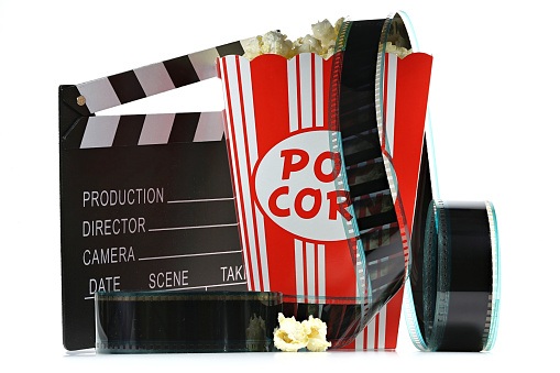 popcorn in a cardboard container with clapperboard and filmstrip isolated on white background