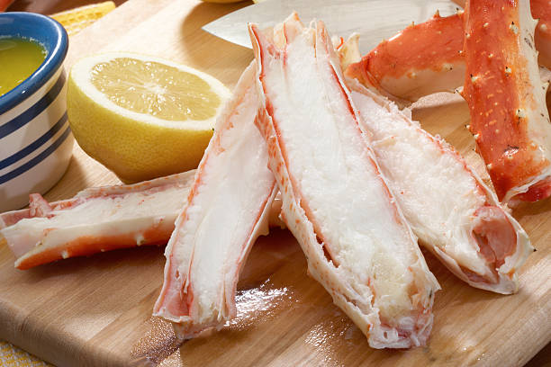 Alaskan king crab legs on a cutting board with a lemon