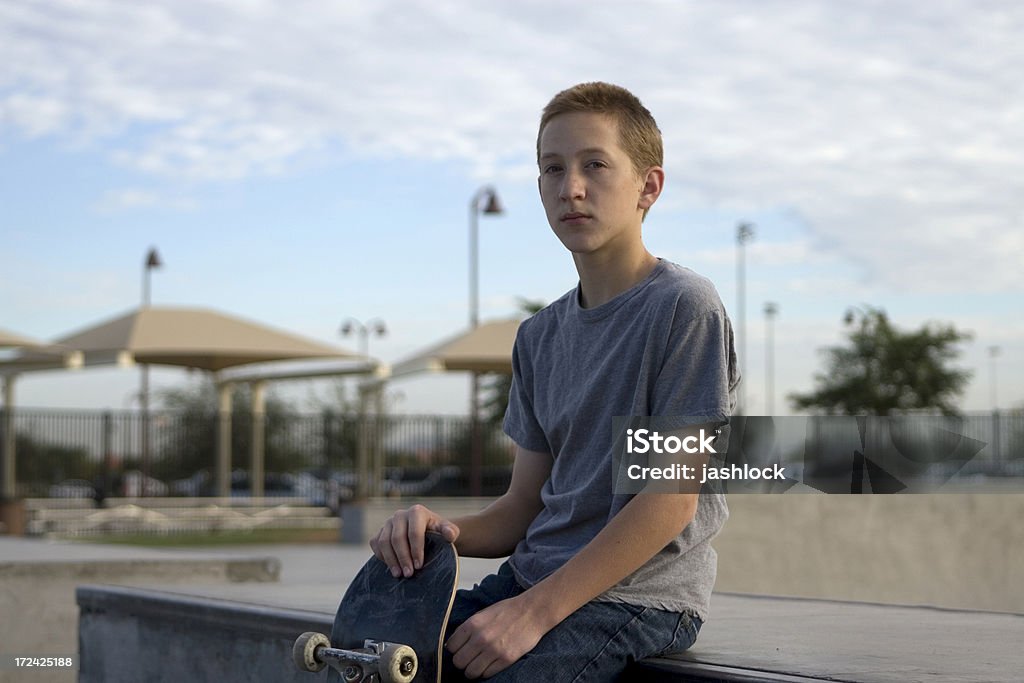 Skaterboy Young male teen sitting with skateboard Adolescence Stock Photo