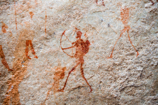 A human figure with bow and arrow painted on the wall of a cave in the Cederberg region of South Africa. The art was created an estimated 1500 years ago by the original Bushman/San inhabitants of the area.