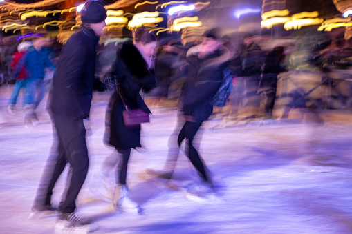 Stockholm - Dec 10, 2017: People skating in the park when the snow is falling in the evening, LED decoration obove the skating area in Kungstrandgarden, Stockholm, Sweden, December 10, 2017