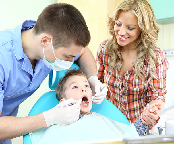 kleiner junge mit seiner mutter besuchen zahnarzt. - human teeth little boys behavior expressing negativity stock-fotos und bilder